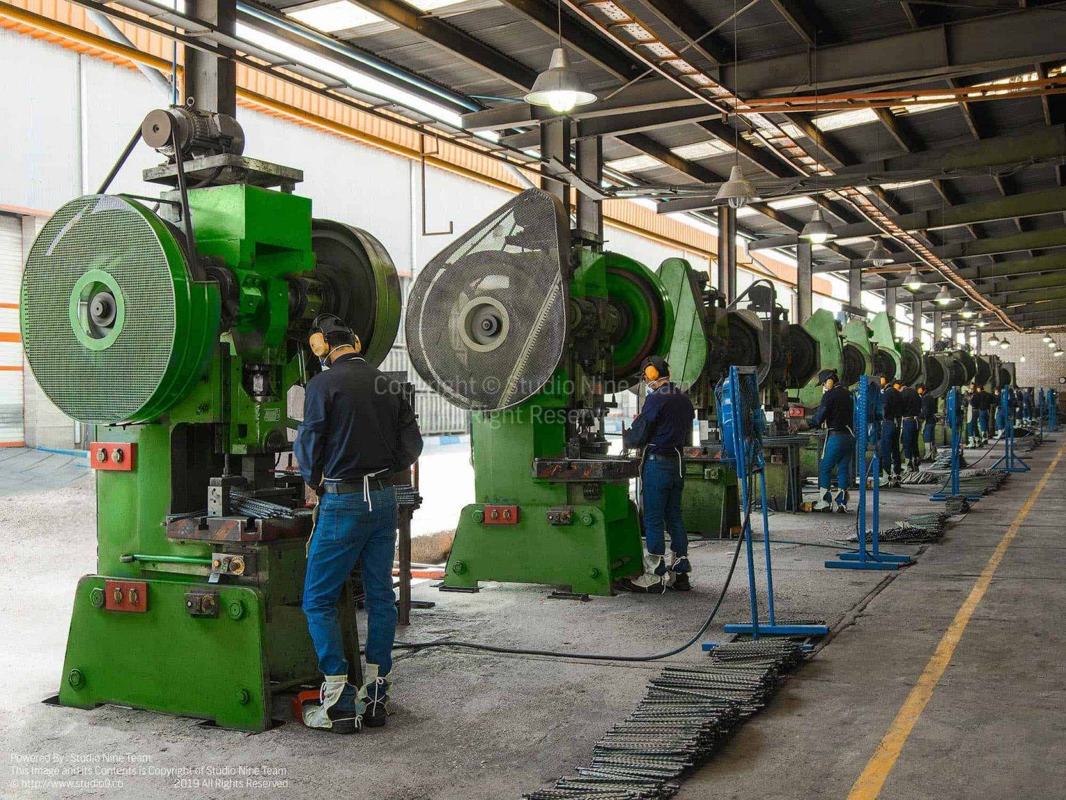 ردیف دستگاه های پرس سبز و اپراتورها در سالن تولید